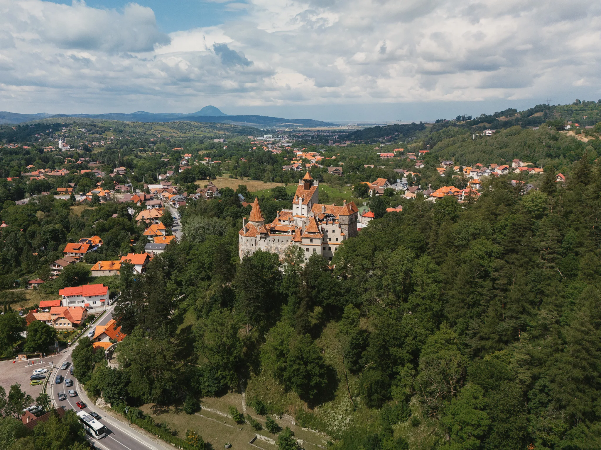 Zamek Bran w Rumunii widziany z drona, otoczony lasem i zabudową miejscowości Bran.