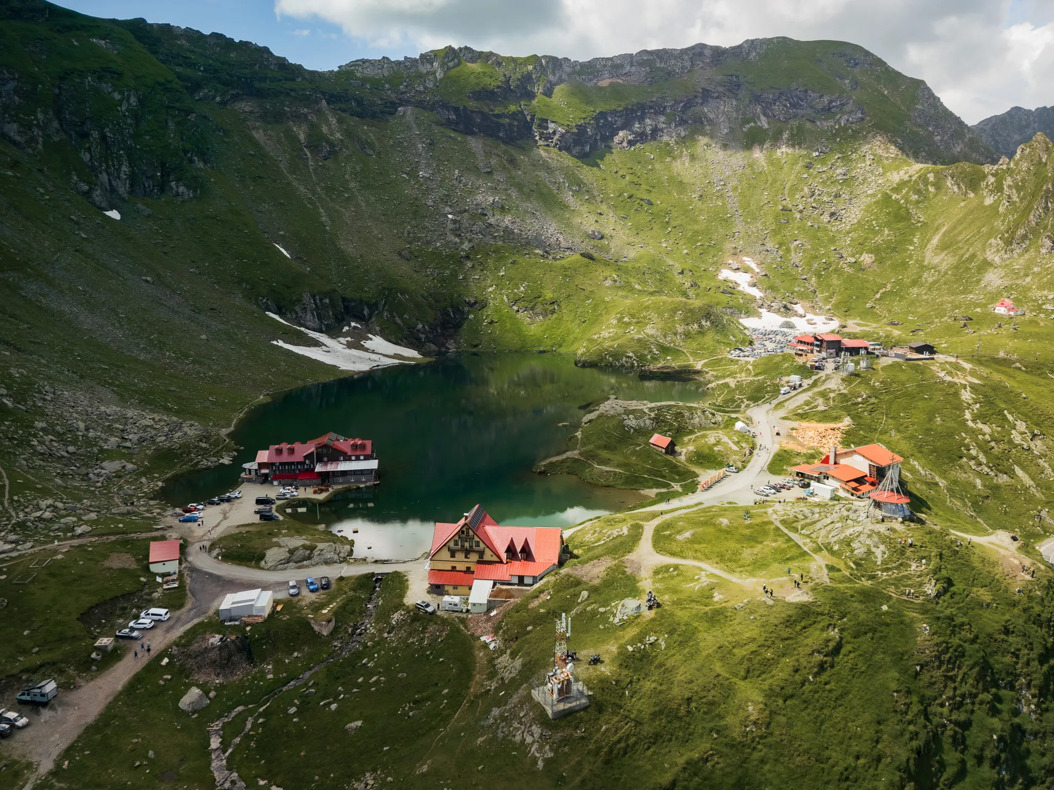 Widok z drona na jezioro Bâlea Lac, schroniska i górskie zbocza przy Trasie Transfogaraskiej.