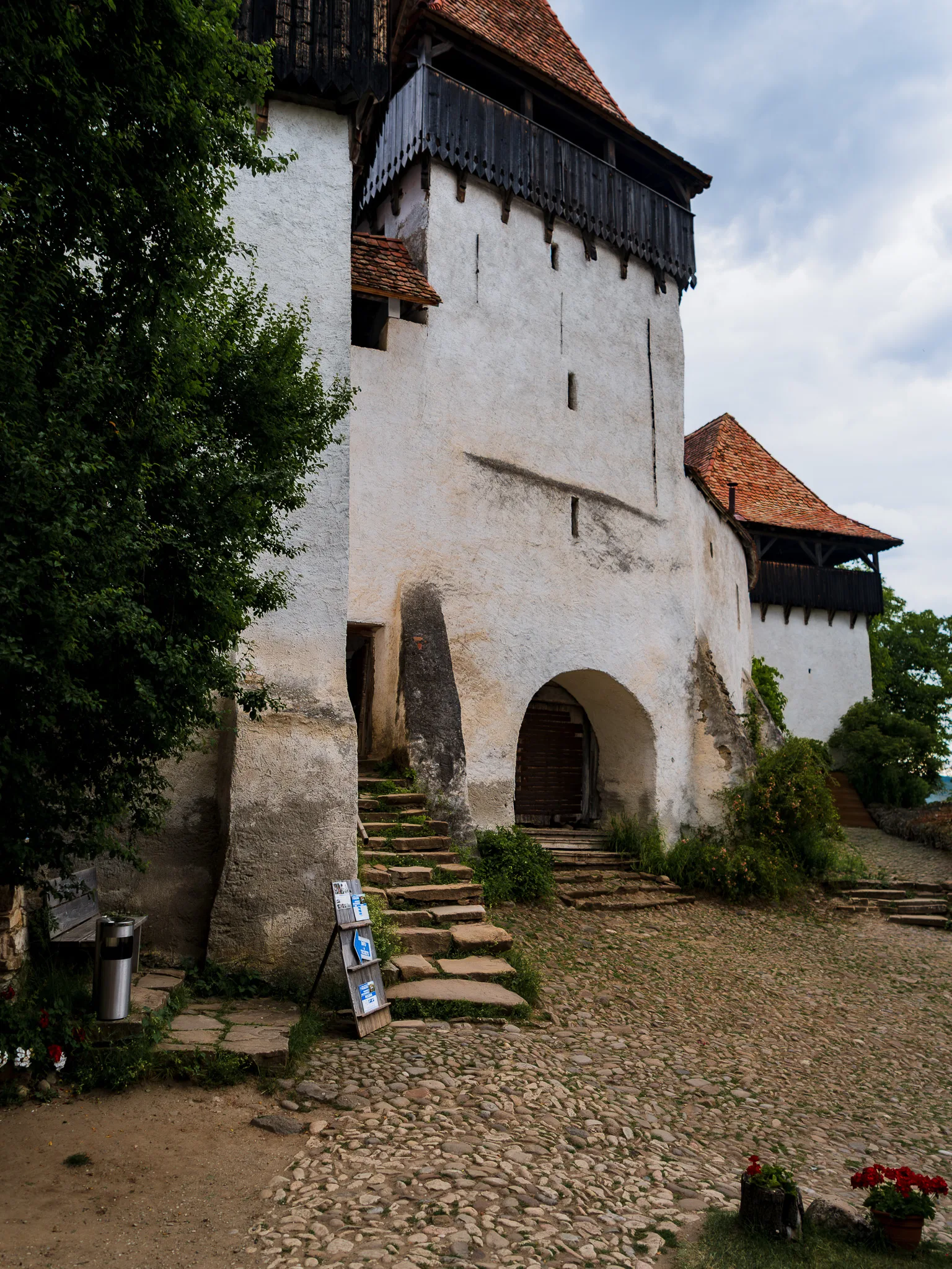 Kościół warowny w Viscri w Rumunii z kobietą stojącą na brukowanym dziedzińcu