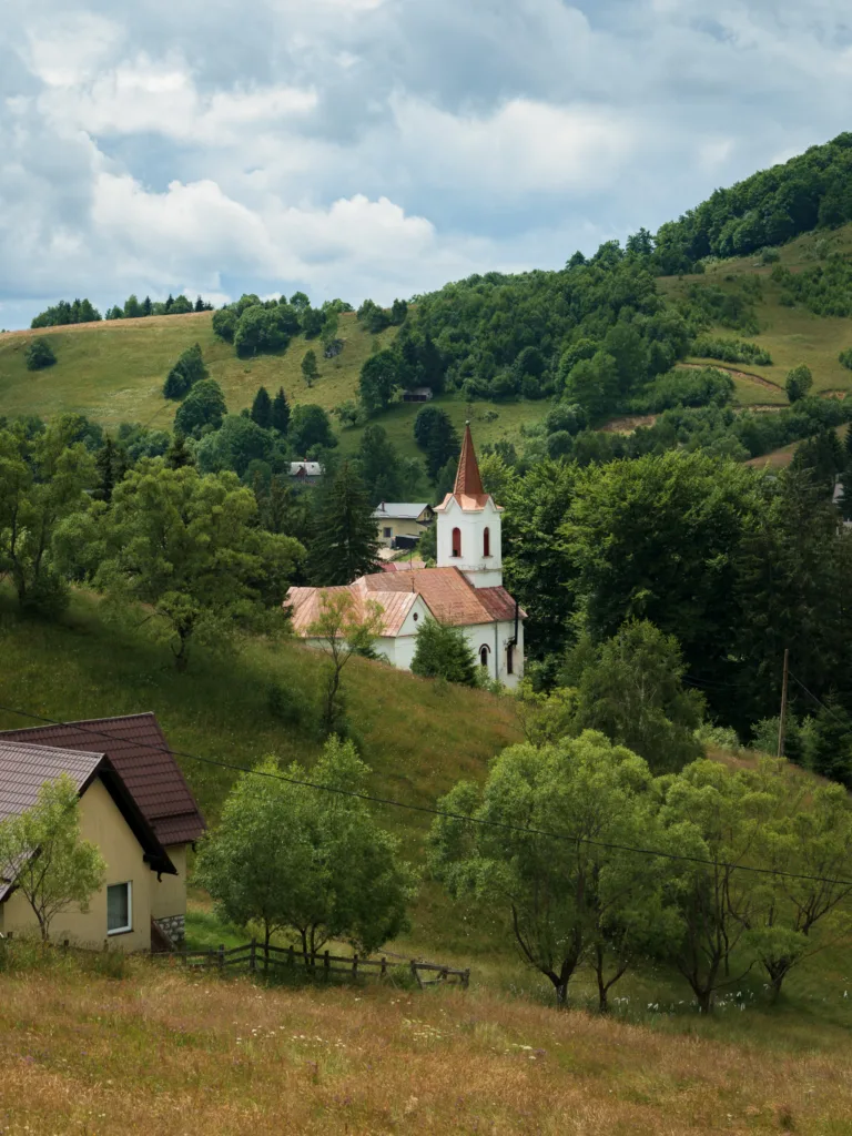 Niewielki kościół położony wśród zielonych wzgórz i lasów w rumuńskich Karpatach.