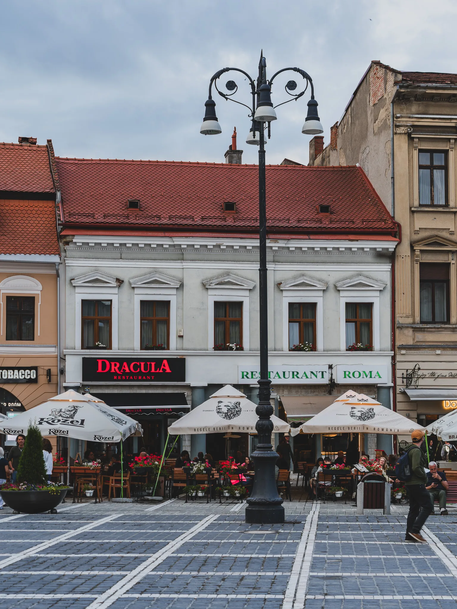 Rynek w Braszowie z restauracjami, ogródkami i zabytkowymi kamienicami przy Piața Sfatului.