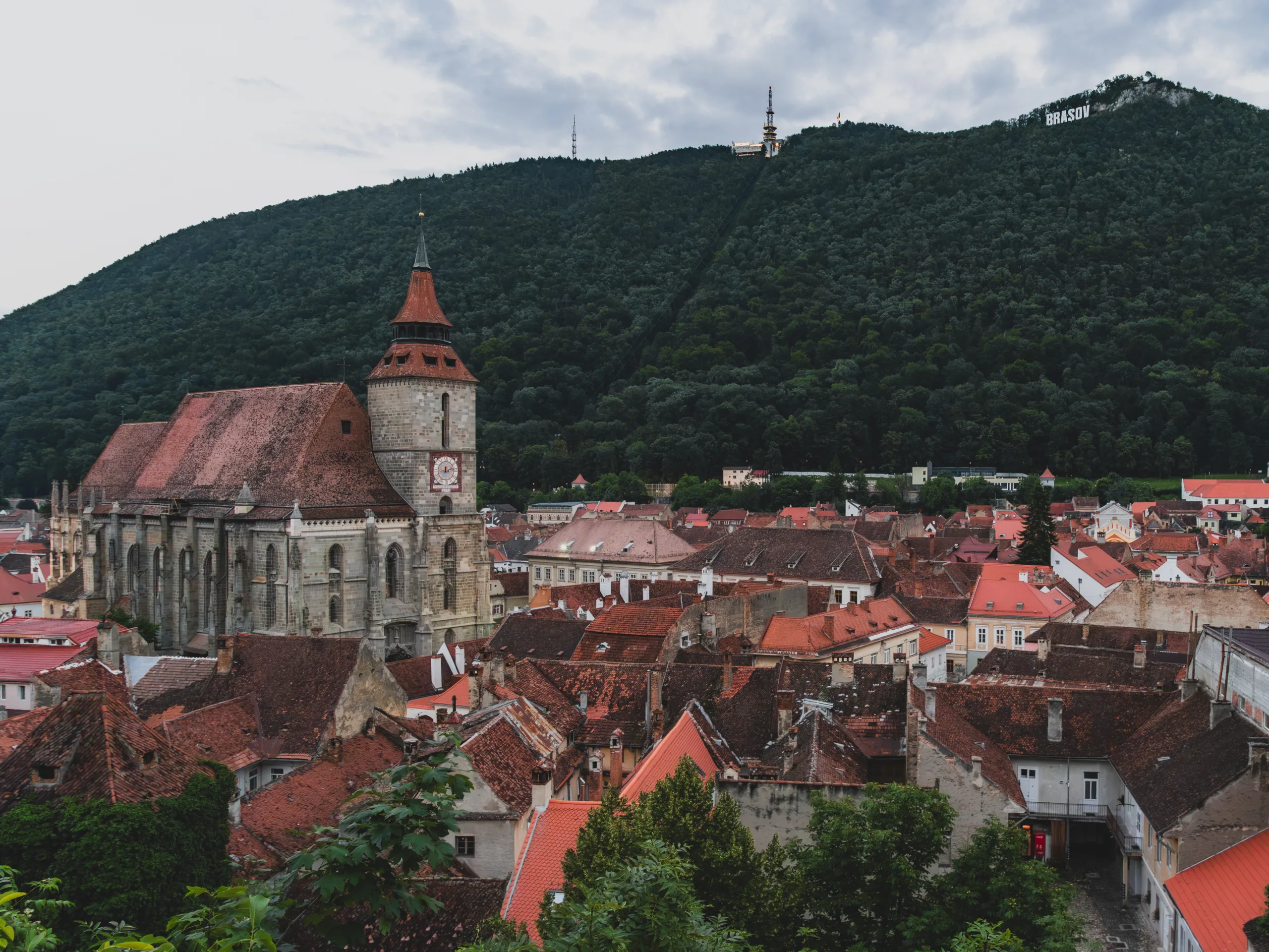 Panorama Starego Miasta w Braszowie z Czarnym Kościołem i wzgórzem Tâmpa z napisem BRASOV w tle.