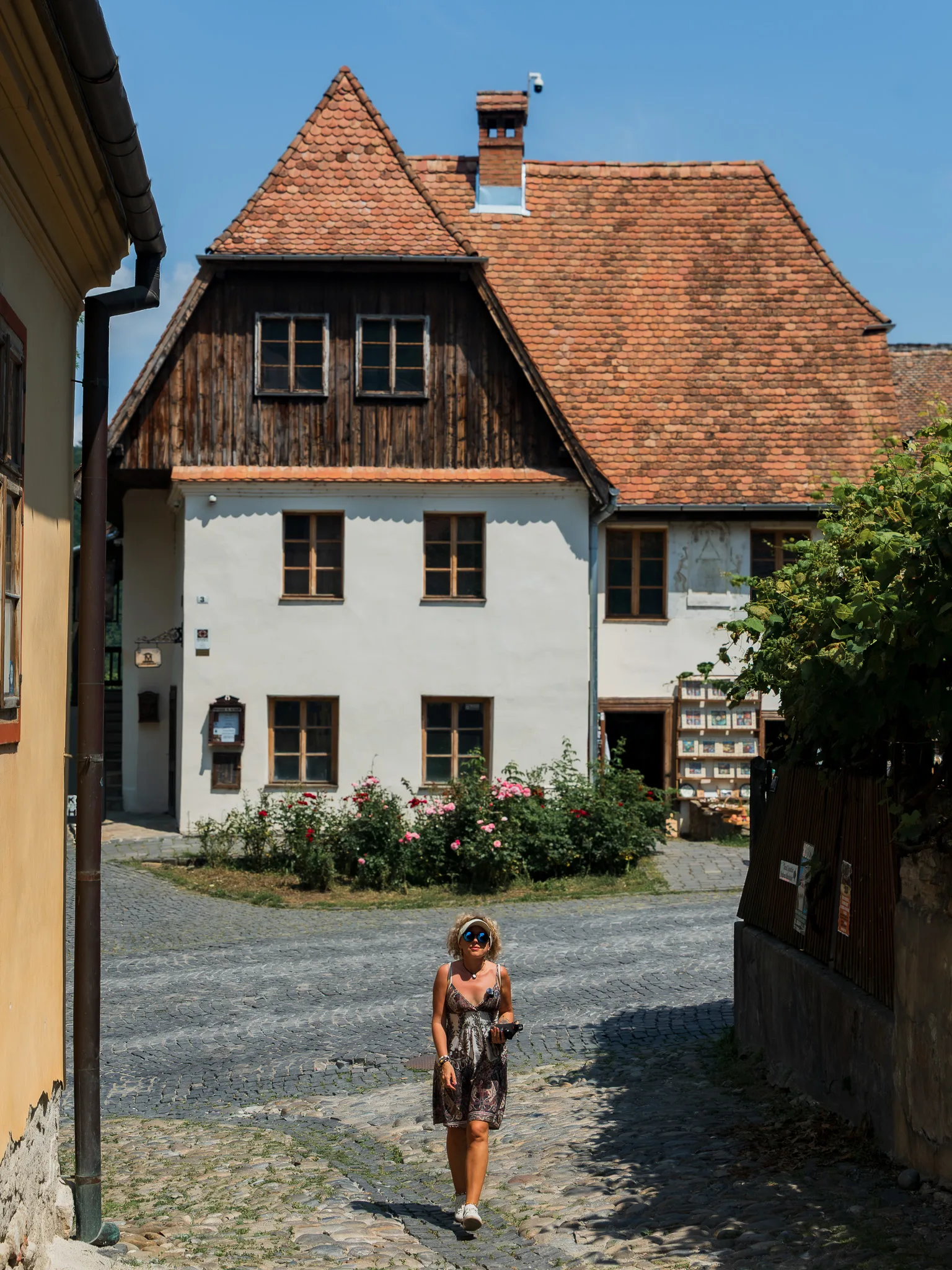 Zabytkowy dom z drewnianą elewacją przy brukowanej ulicy w Sighișoarze.