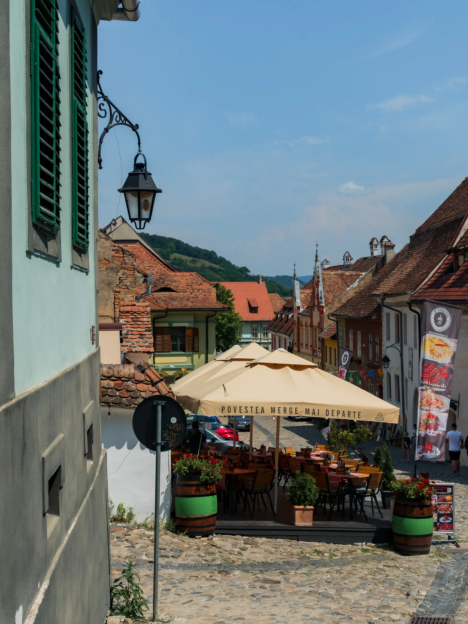 Brukowana uliczka z restauracjami i zabytkowymi kamienicami w cytadeli Sighișoary.
