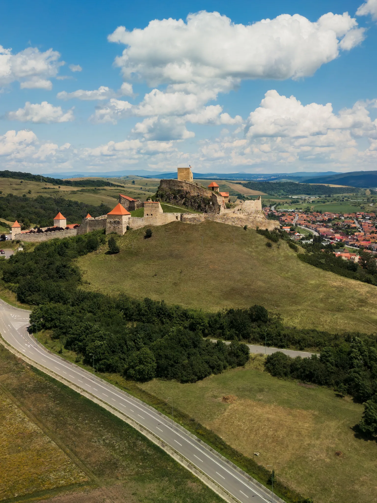 Twierdza Rupea w Rumunii widziana z drona, z murami obronnymi, wieżami i zabudową miasta w tle