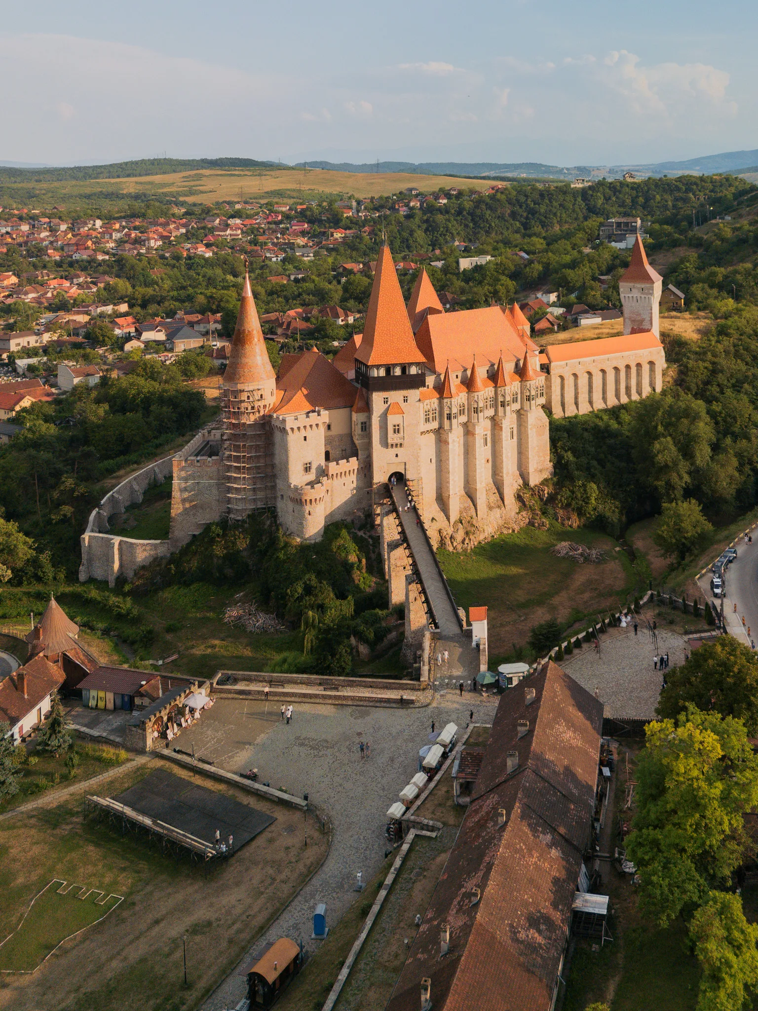 Zamek Korwinów w Hunedoarze widziany z drona w ciepłym, popołudniowym świetle.