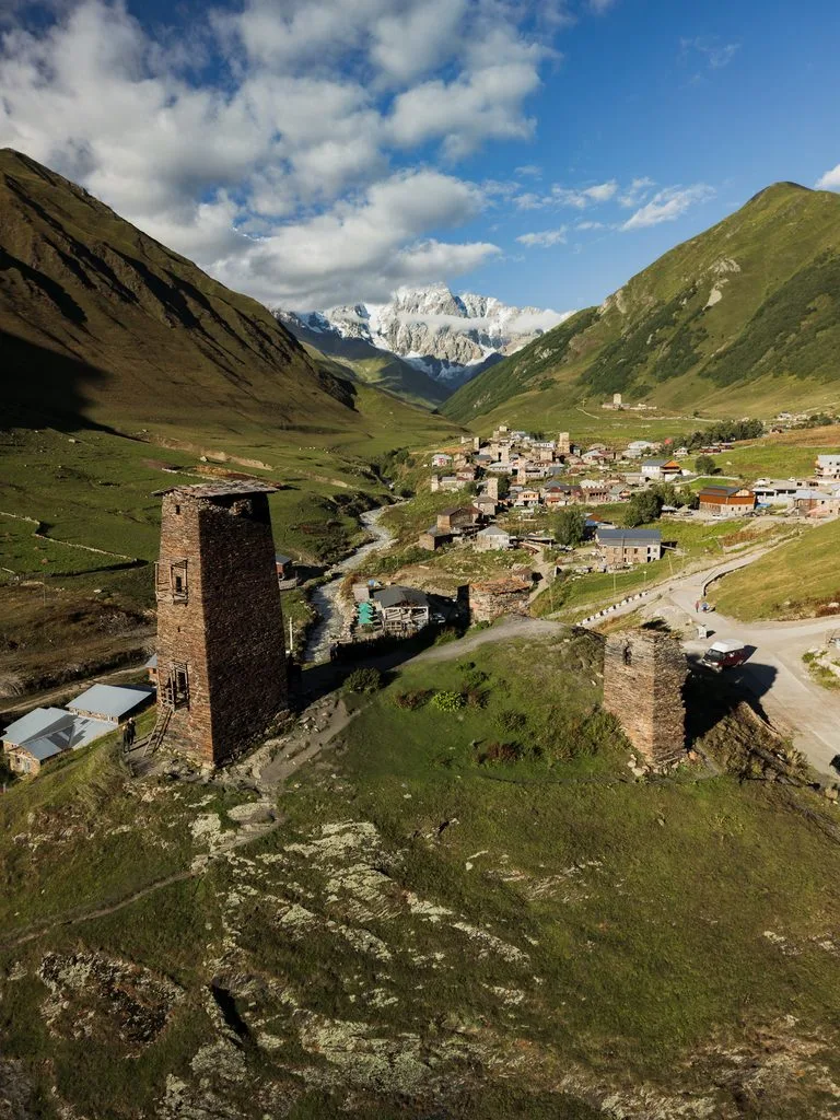 Panorama Ushguli ze swańskimi wieżami, doliną i ośnieżonymi szczytami Kaukazu.