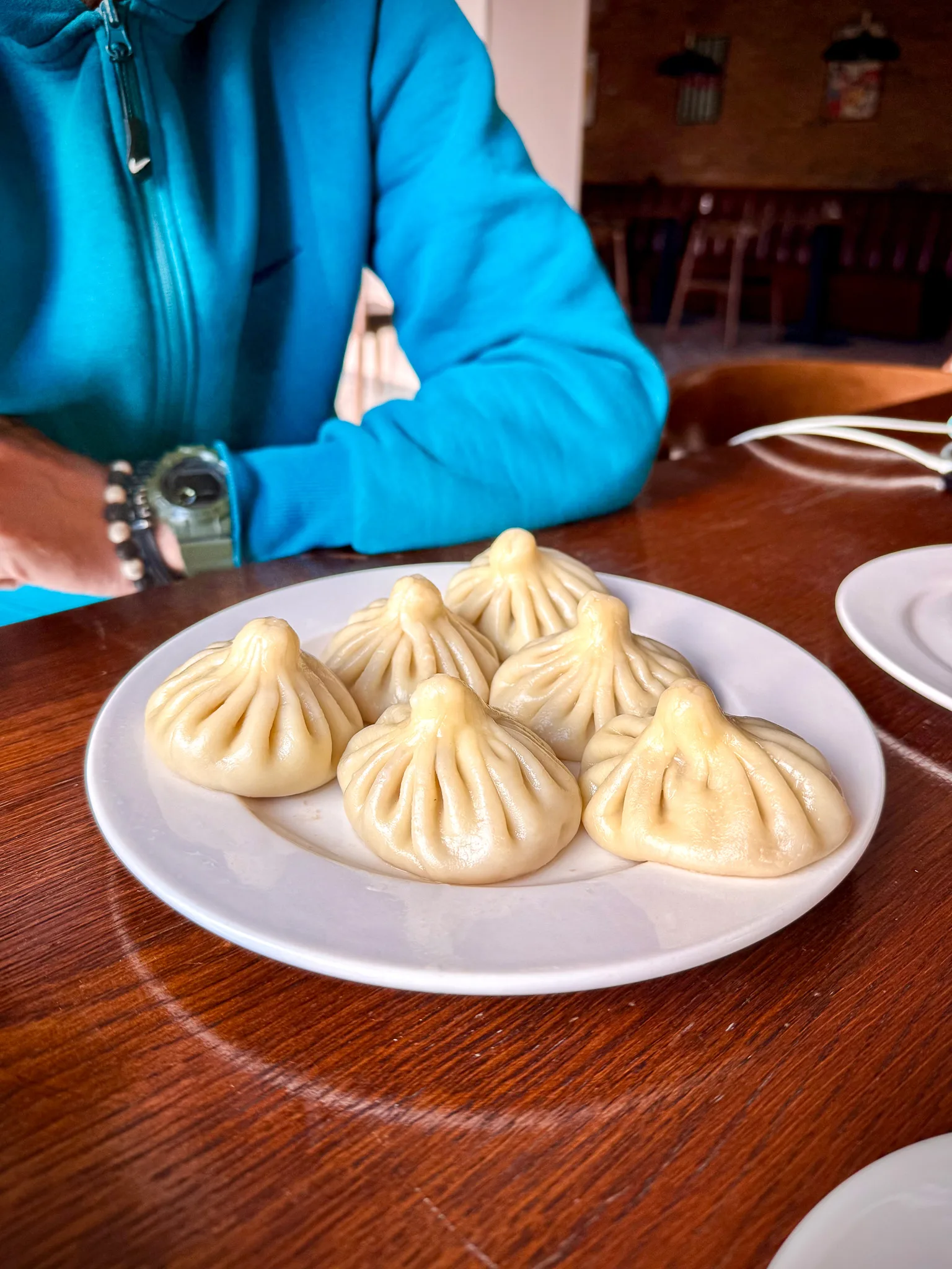Chinkali – tradycyjne gruzińskie pierożki z charakterystycznymi fałdkami, podane na białym talerzu w restauracji w Gruzji.